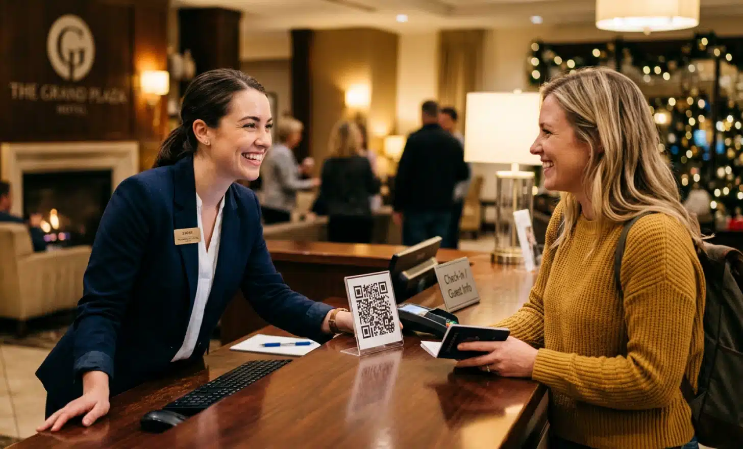 Hotel staff member assisting a guest at reception with a QR code visible on the counter.